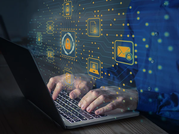 Eine Person tippt auf der Tastatur eines Laptops, während um sie herum digitale Symbole für Datenschutz und Sicherheit, wie Vorhängeschlösser und geschützte E-Mail-Symbole, schwirren.